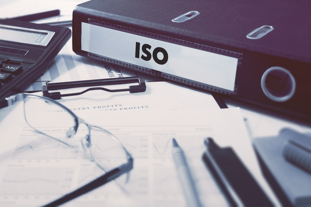 Office folder with inscription ISO - International Organization for Standardization - on Office Desktop with Office Supplies. Business Concept on Blurred Background. Toned Image.